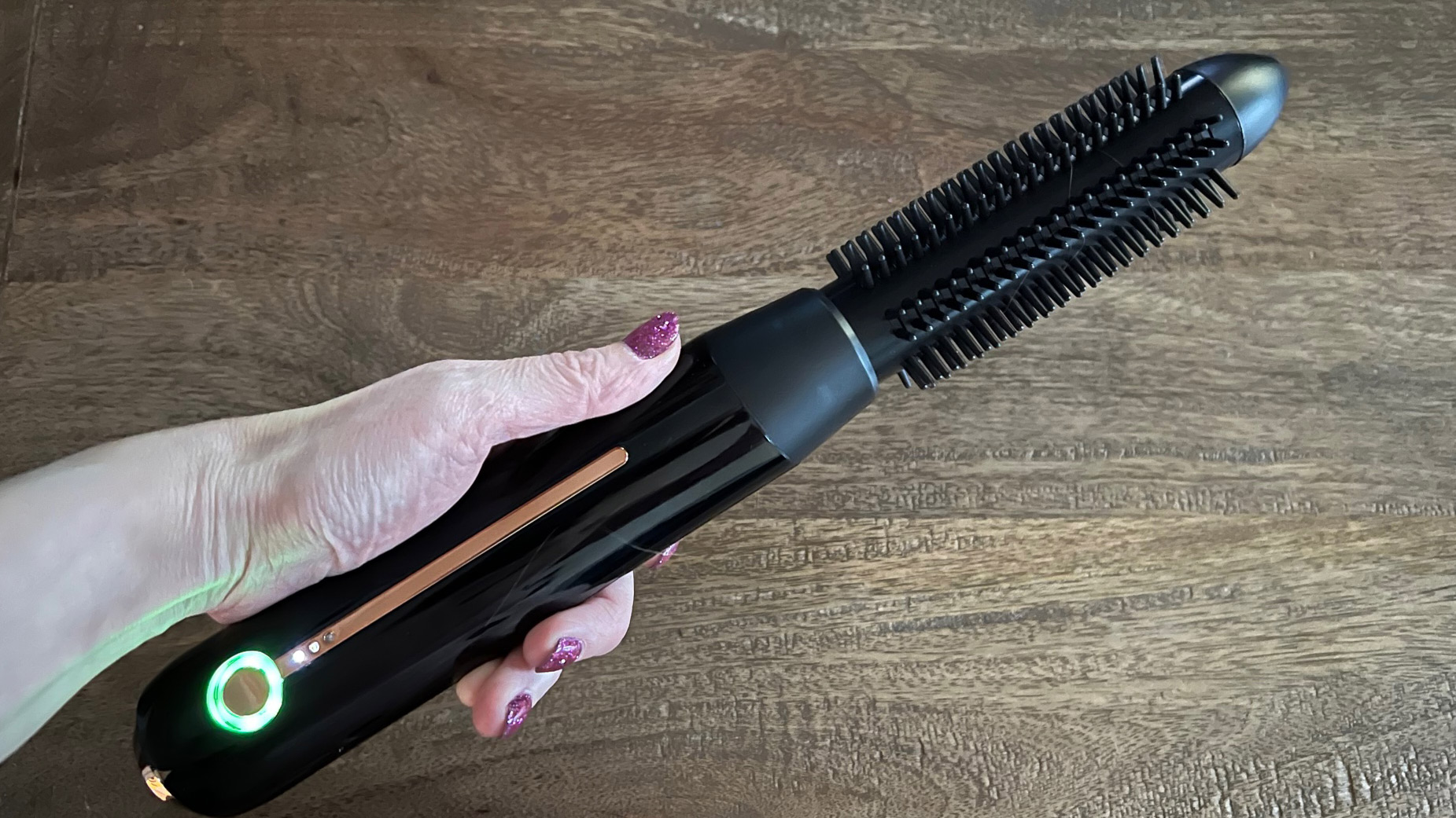 The BaByliss 900 cordless hot brush being held ready to use