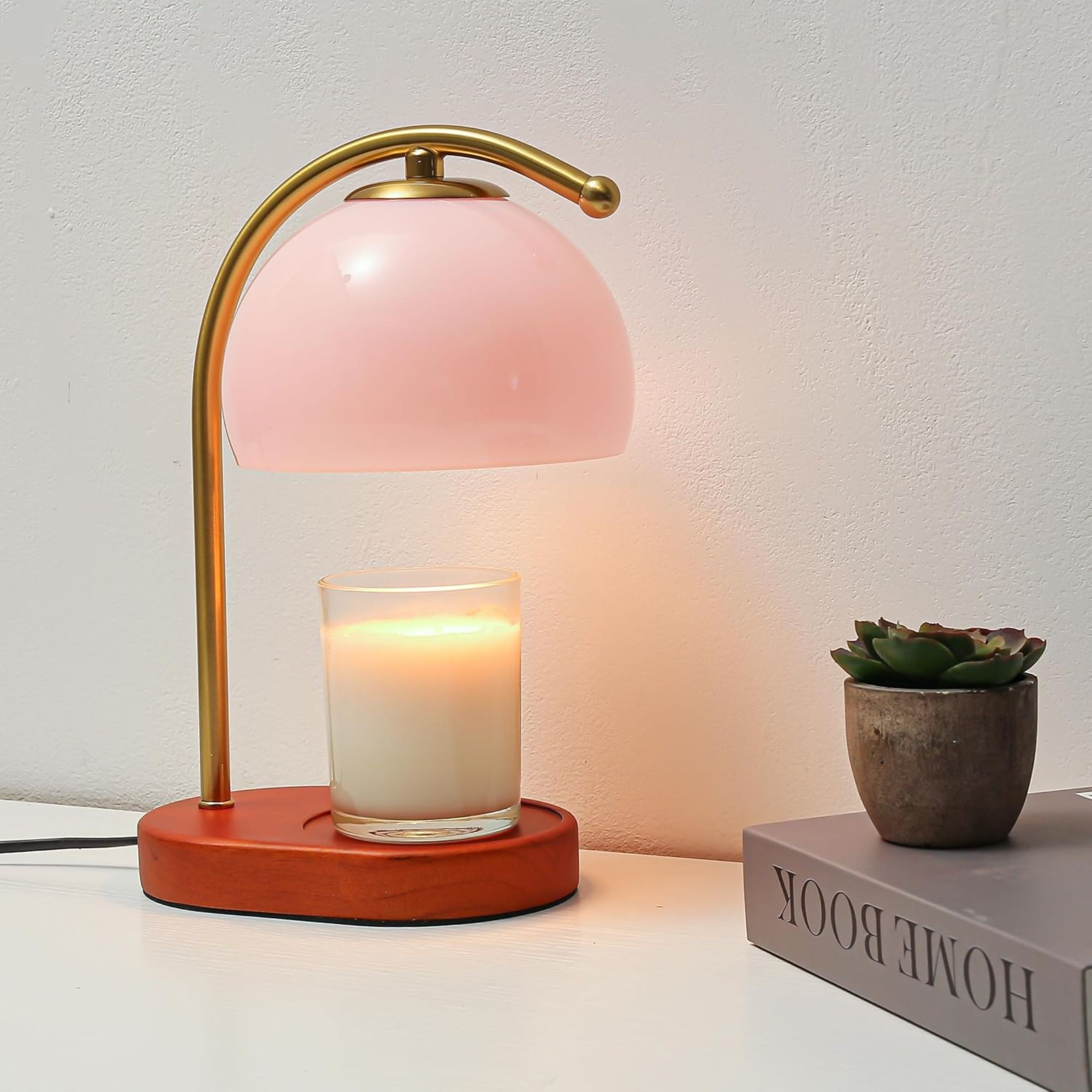 Candle warmer with wooden base and metal stem, with a pale pink glass lamp