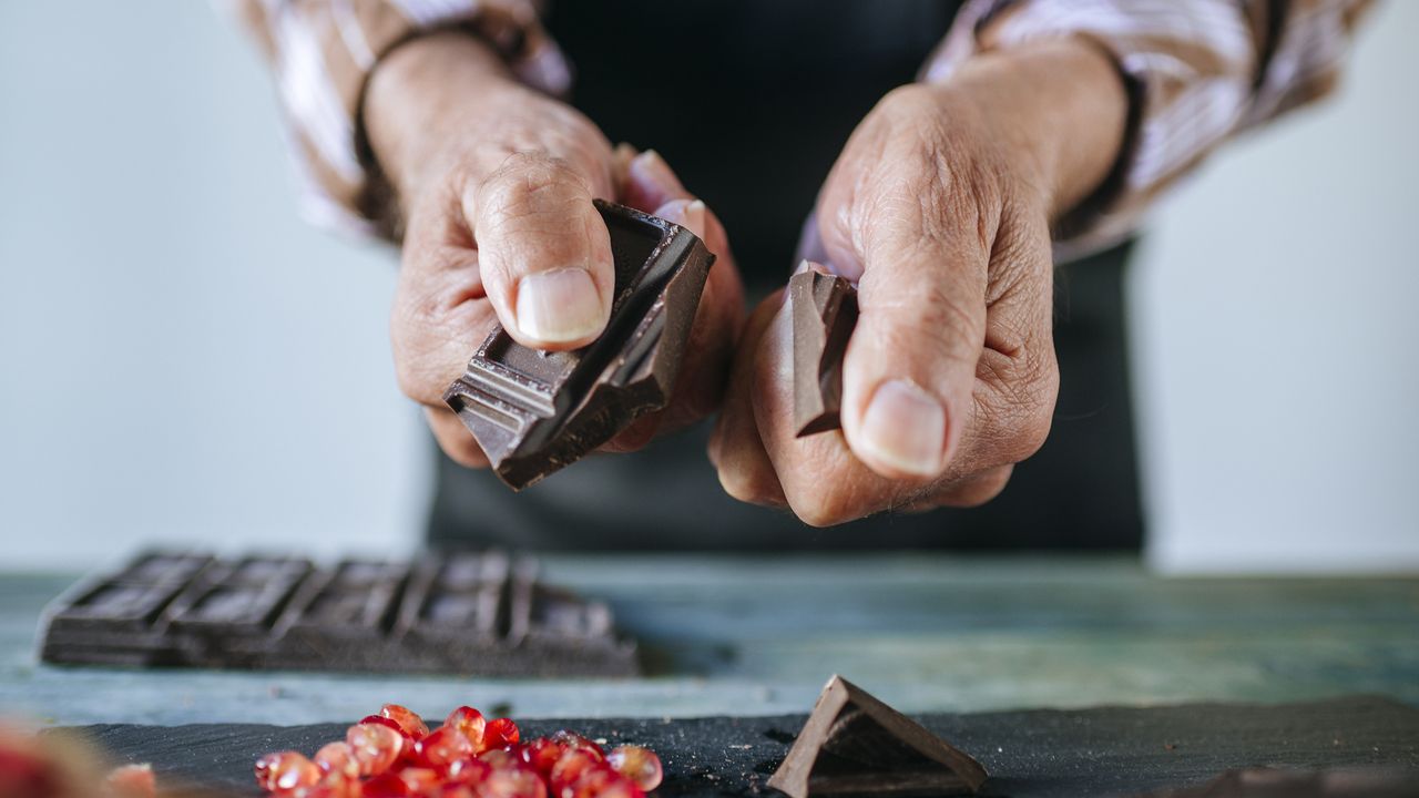 Person breaking some dark chocolate