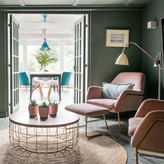 living room with pink furniture and green wall