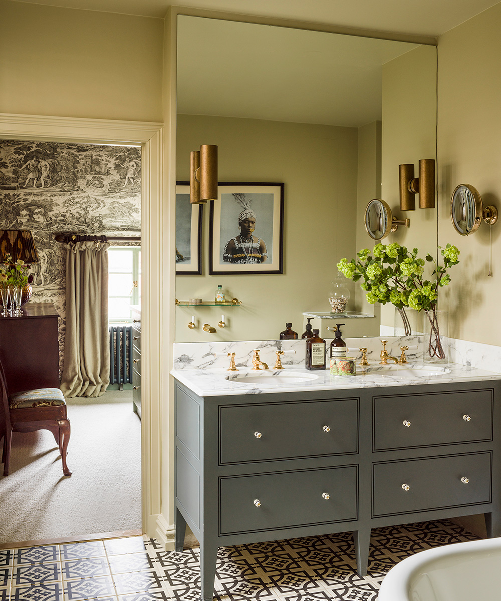 An example of bathroom paint ideas showing a neutral en-suite with a double vanity unit in front of a mirrored wall