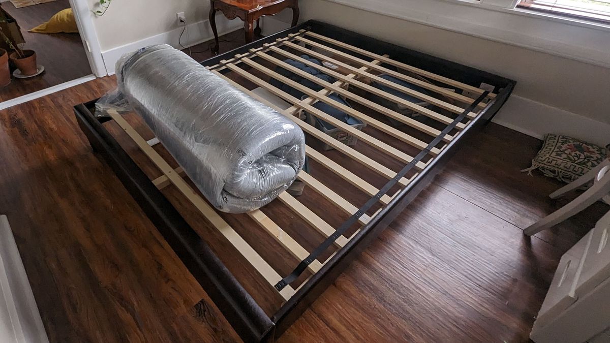 Casper Original mattress in its plastic wrapping on the bed frame