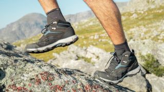 Man's feet wearing Quechua Waterproof MH100 hiking shoes