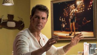 Tom Cruise as Jack Reacher, with a portrait of AC/DC playing live Photoshopped onto the wall behind him