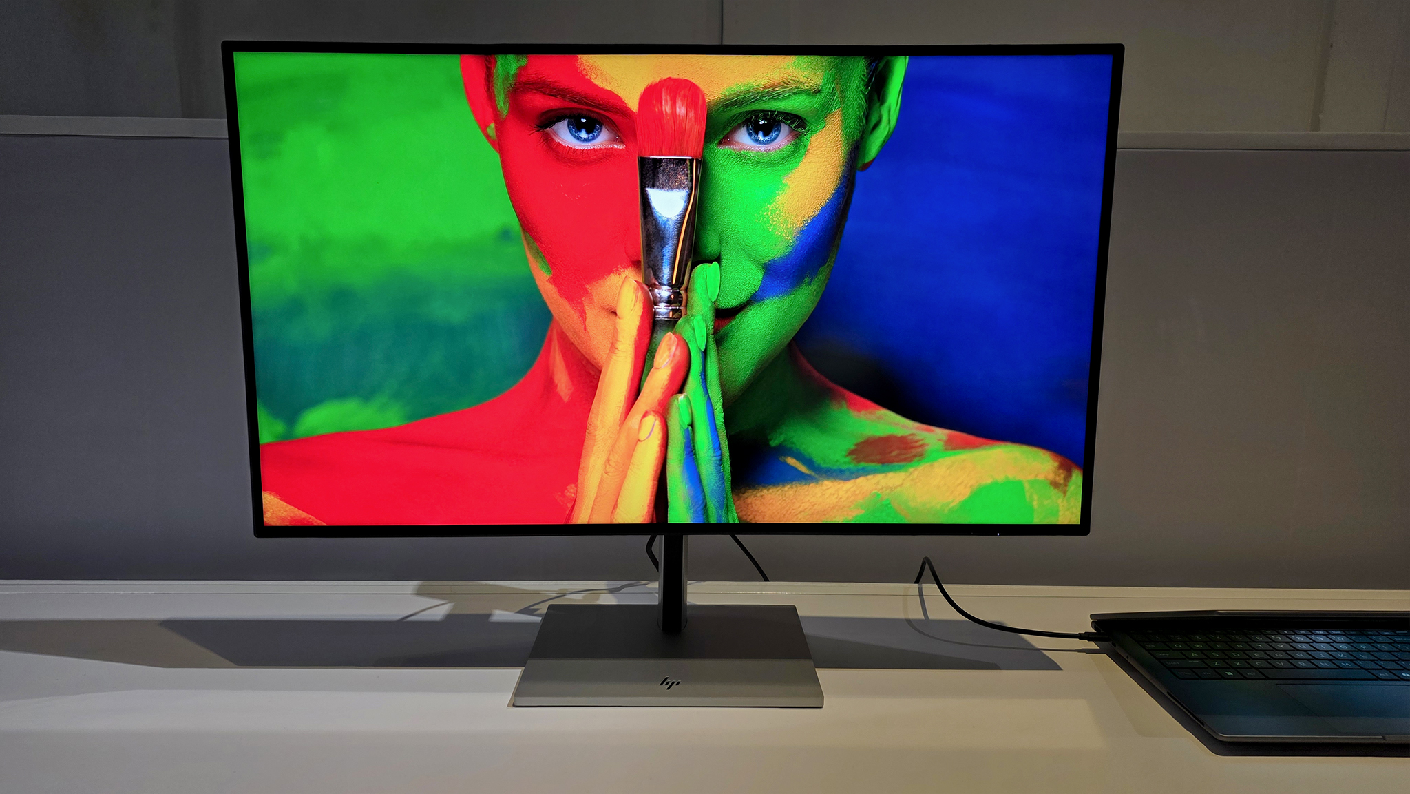 HP Series 7 Pro 4K Monitor showing a colorful image of a woman holding a brush. 