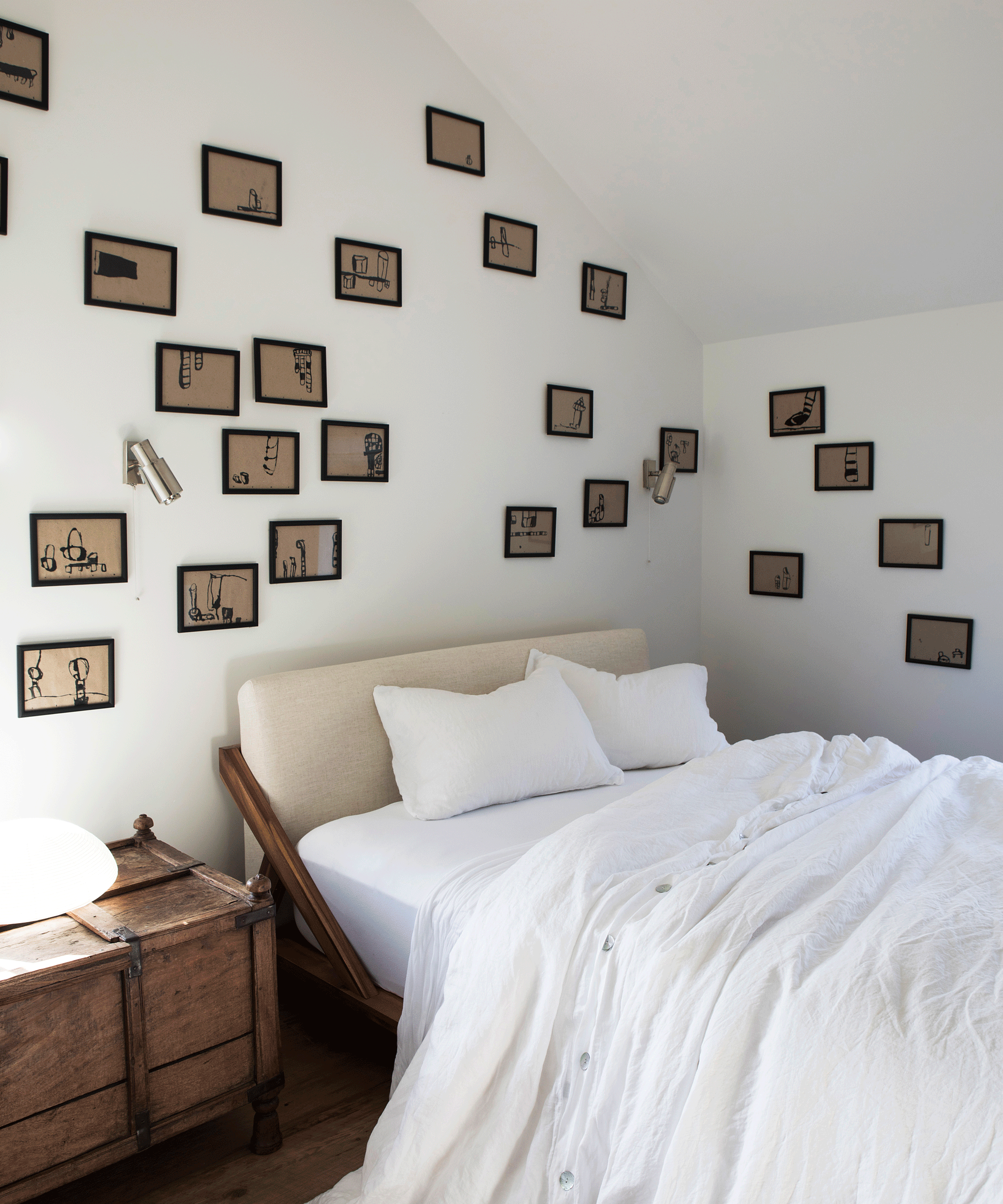White bedroom with randomly placed wall art