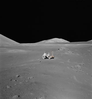 A barren gray landscape with the lunar roving vehicle sitting in the center of the image.