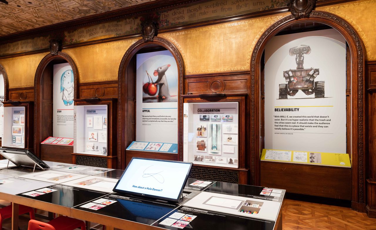 Design boards displayed within wooden, arched alcoves. A table in front displays screens and text about the company&#039;s design process