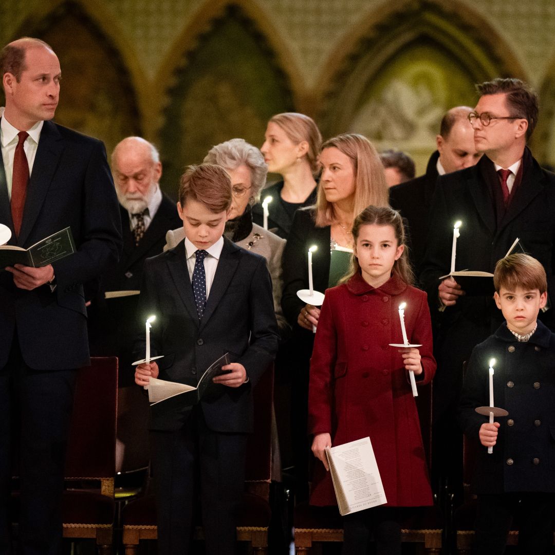 Prince William wears a suit and looks at his family, Prince George, Princess Charlotte, Prince Louis, and wife Kate Middleton who wears a white suit