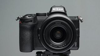 Nikon Z5, one of the best Nikon cameras, on a tripod in front of a blue background