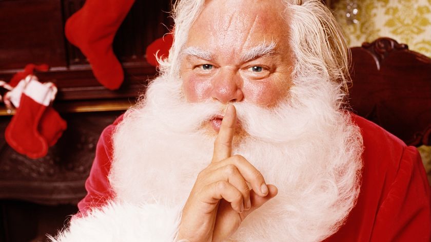 Santa requesting silence and privacy by holding a finger to his lips