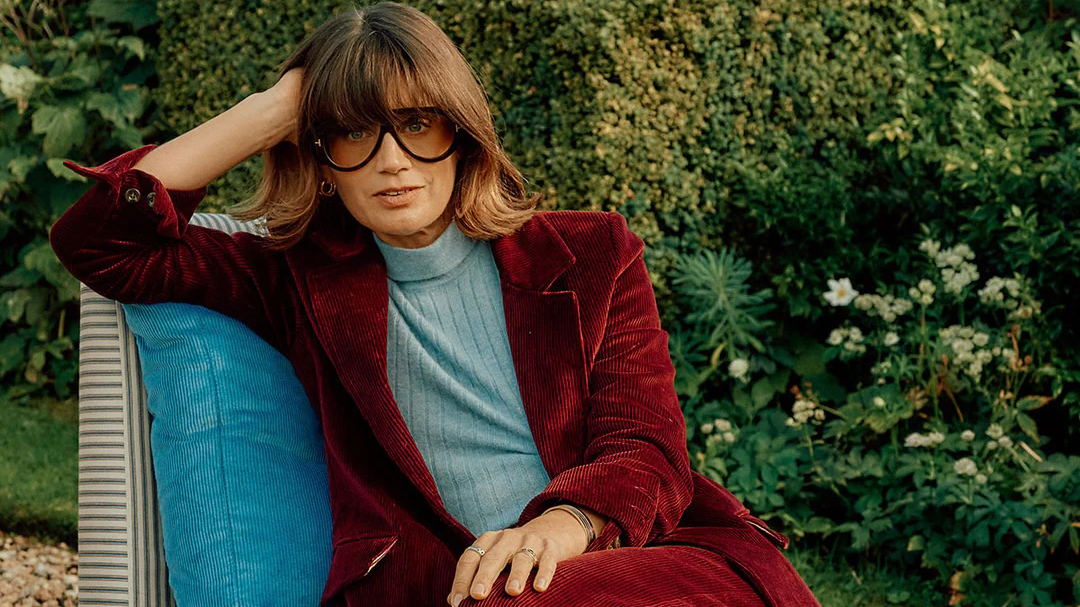 Sarah Corbett-Winder wearing a Burgundy velvet suit and pale blue polo neck