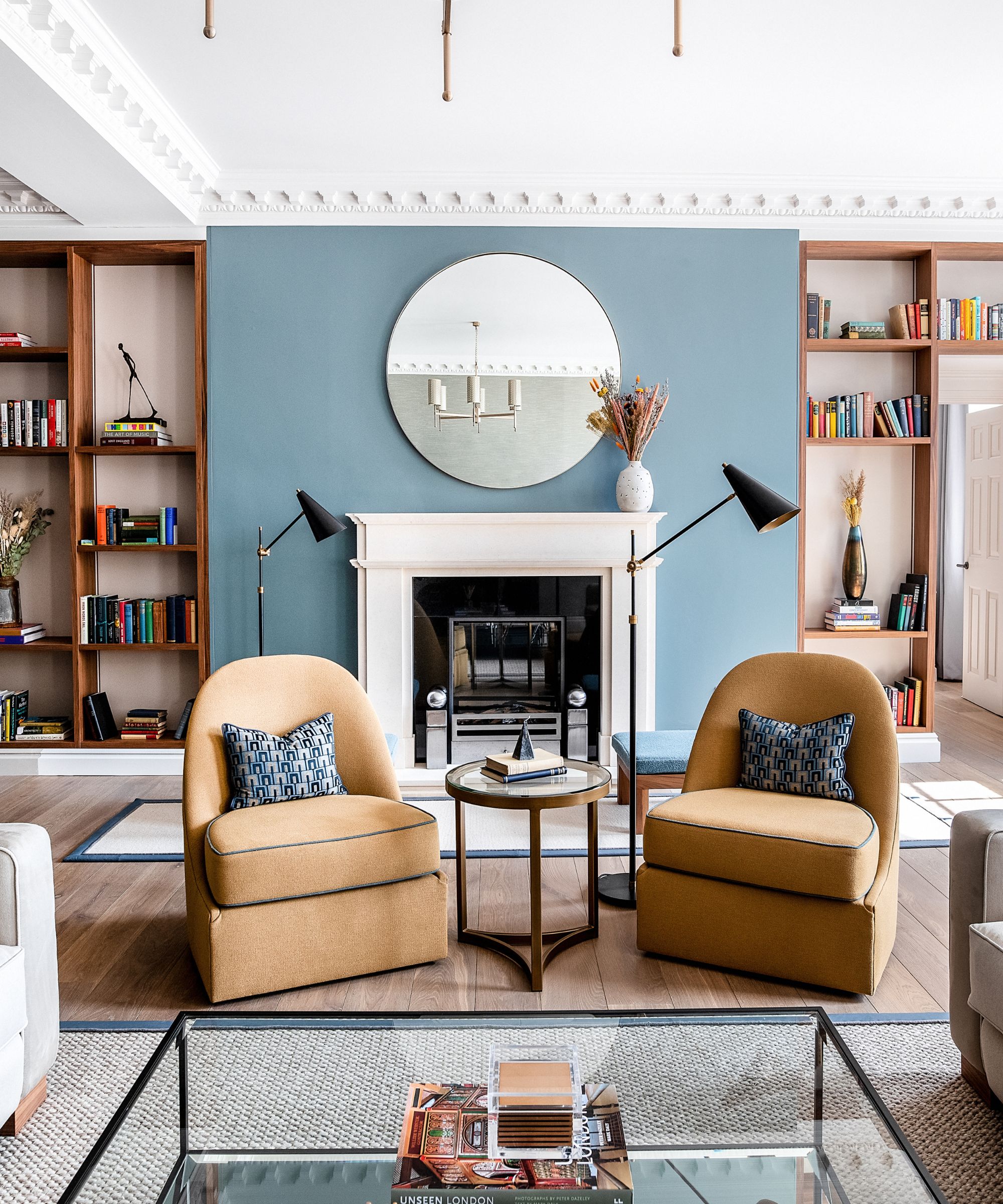 White fireplace, brown chairs, glass table