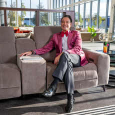 Craig Revel Horwood sat on a grey sofa in the Sofology show room.