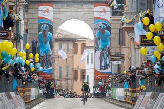 Tirreno-Adriatico stage 5 winner Adam Yates rides into Filottrano under banners honouring Michele Scarponi