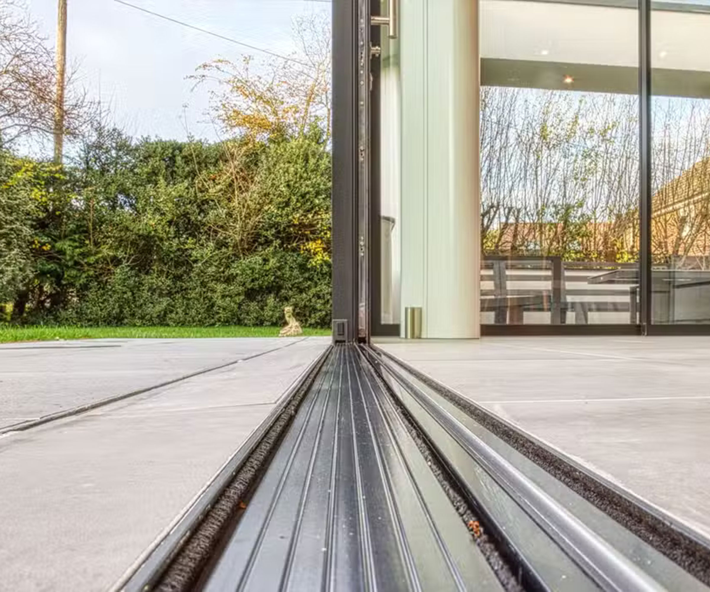 close up detail image of a flush track system in the ground for a set of exterior sliding doors