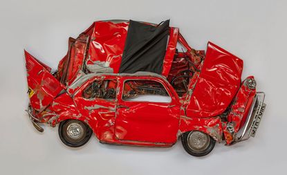 Red car crushed on its side