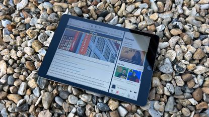 A photograph of the 12.9in 2021 Apple iPad Pro on a bed of stones