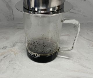 Vietnamese phin coffee maker with glass carafe undreneath