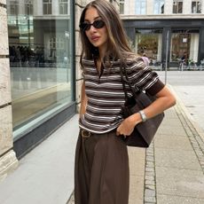 Woman in striped polo and brown pants
