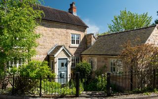 19th-century stone cottage with iron railings