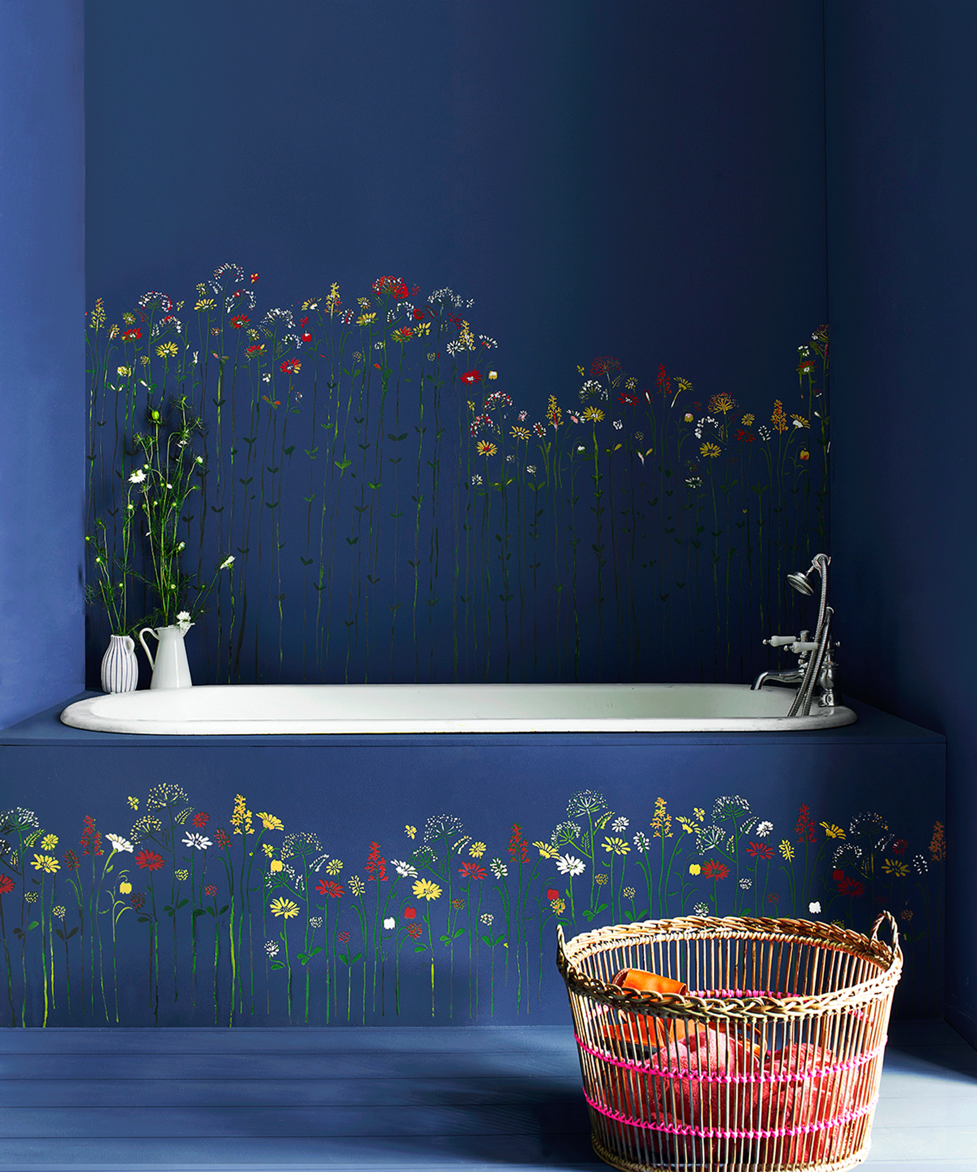 Floral paint stenciling on blue bath with blue walls and woven laundry basket