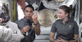 NASA astronauts Raja Chari and Kayla Barron demonstrate non-verbal communication in space, which can be vital on spacewalks and other situations, in an agency video.