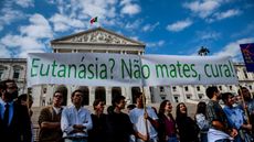 Protestors hold a banner reading ‘Euthanasia? Don't kill, cure!’ during a demonstration against the decriminalisation of euthanasia 