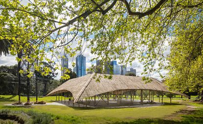 This year’s MPavilion by Bijoy Jain has just been launched in Melbroune’s Queen Victoria Gardens. An outdoor pavilion made of bamboo in a park with the city in the background.