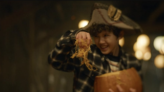 A still from the movie Carved of a young kid holding a pumpkin