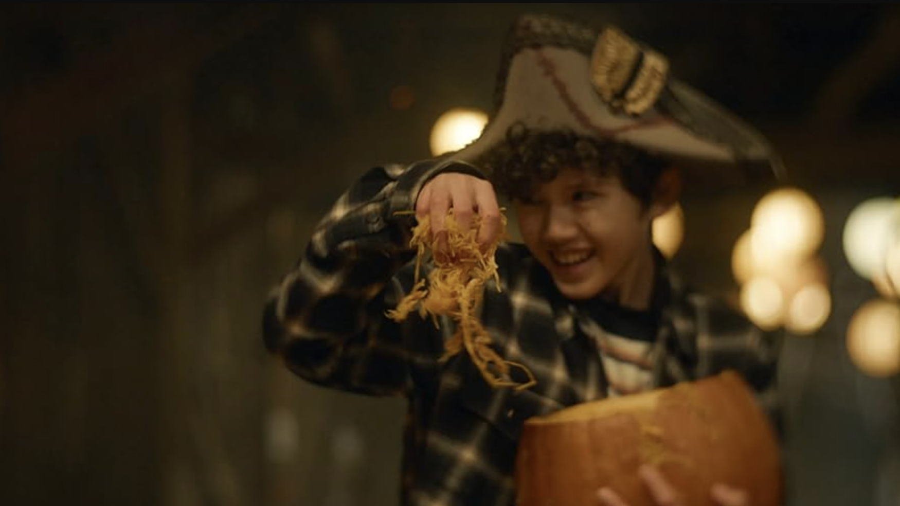 A still from the movie Carved of a young kid holding a pumpkin