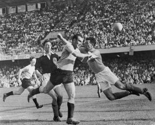 Uruguay's Óscar Míguez heads the ball over the bar in a game against Scotland at the 1954 World Cup.