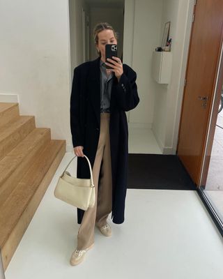 @anoukyve wearing a cream bag with trousers and coat