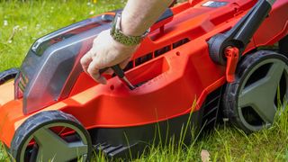Man adjusting the blade length on a lawnmower