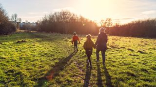 A woman and her children walk through a park in the winter sun in order to boost melatonin levels