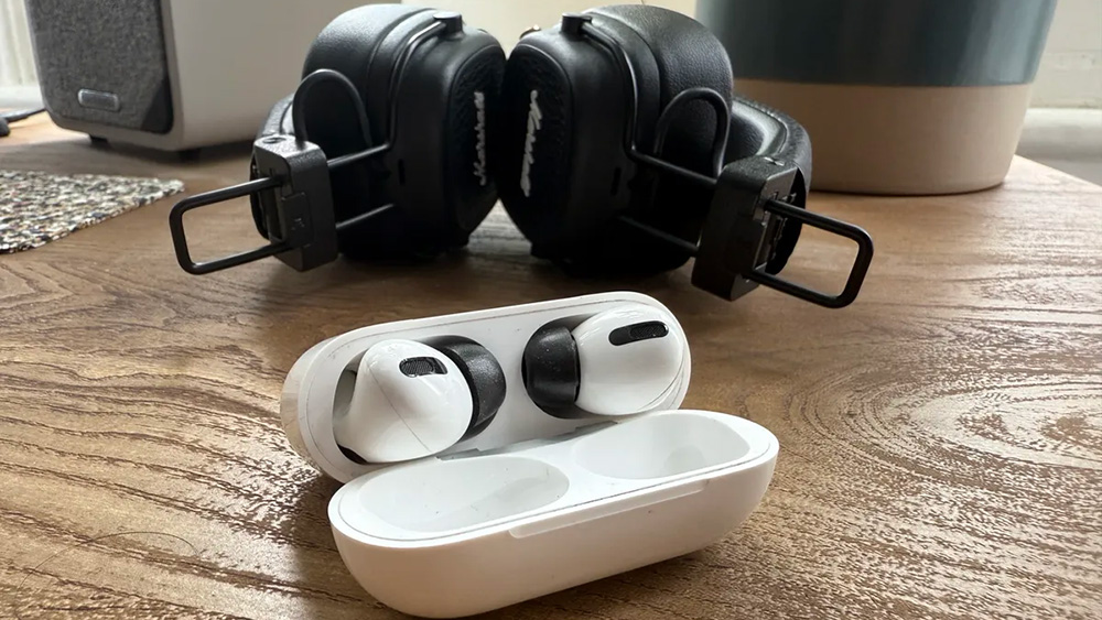 AirPods Pro in their case next to black Marshall over-ear headphones