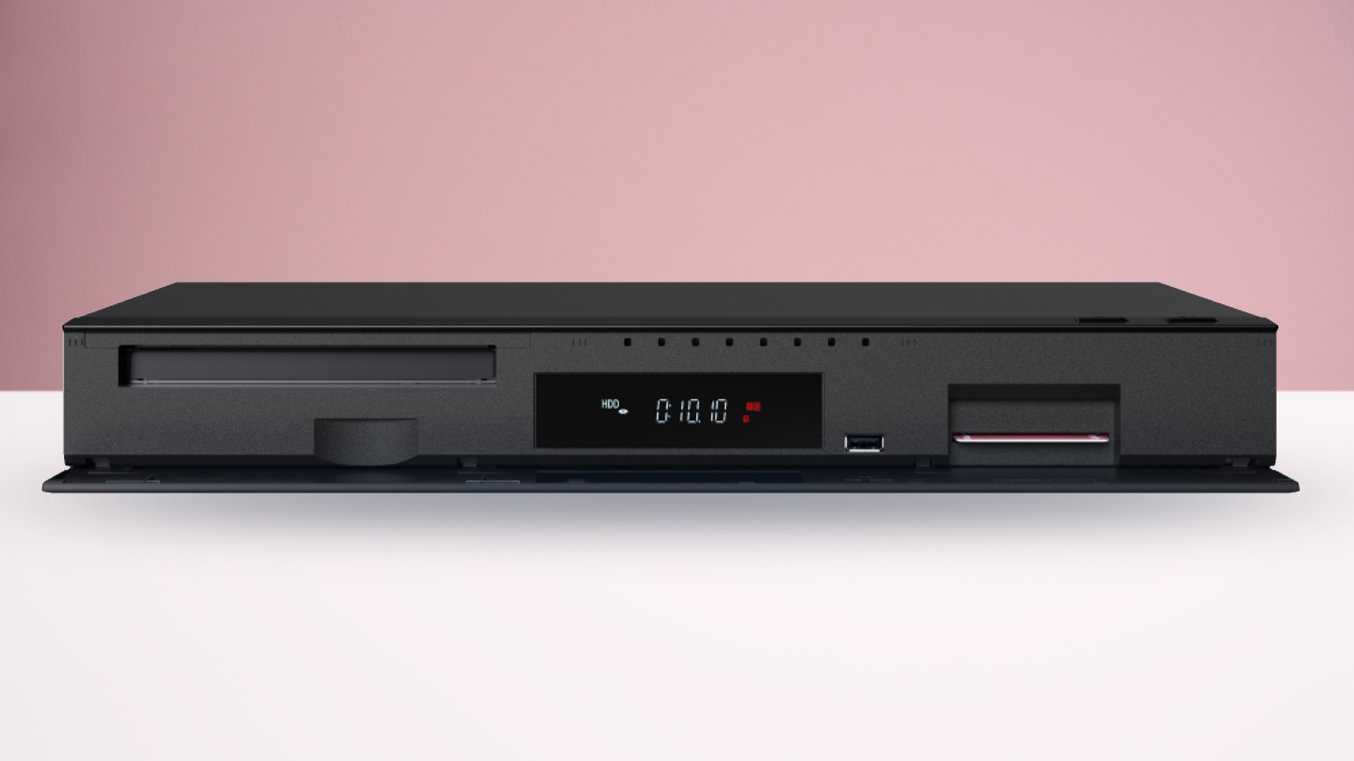 The Panasonic DMR-4X1010 Blu-ray player on a white surface with a pink background