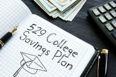 529 College Savings Plan is written in a notebook next to a pen and calculator.