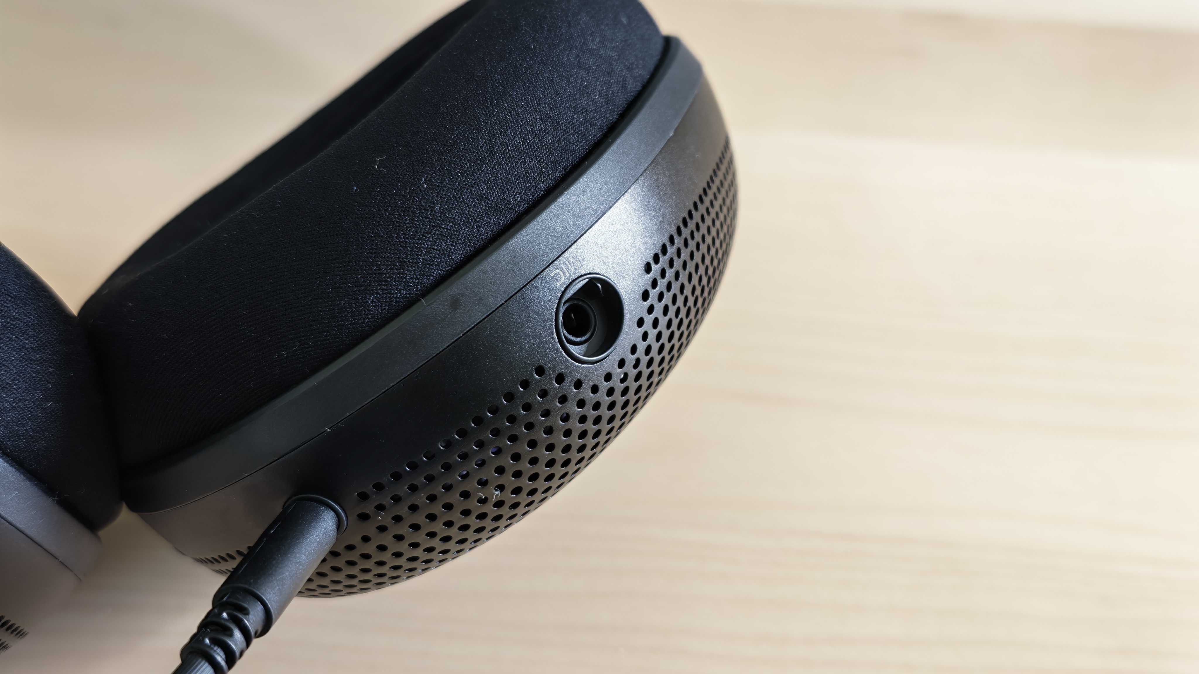 A photo of the Inzone H6 Air gaming headset positioned above a wooden desktop surface.