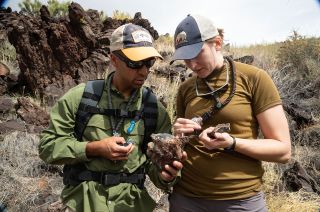 New NASA astronauts Raja Chari and Kayla Barron examine rock samples during geology training in Arizona. Together with their class members, the "Turtles" are now eligible for assignments on future Artemis missions to the moon's surface.