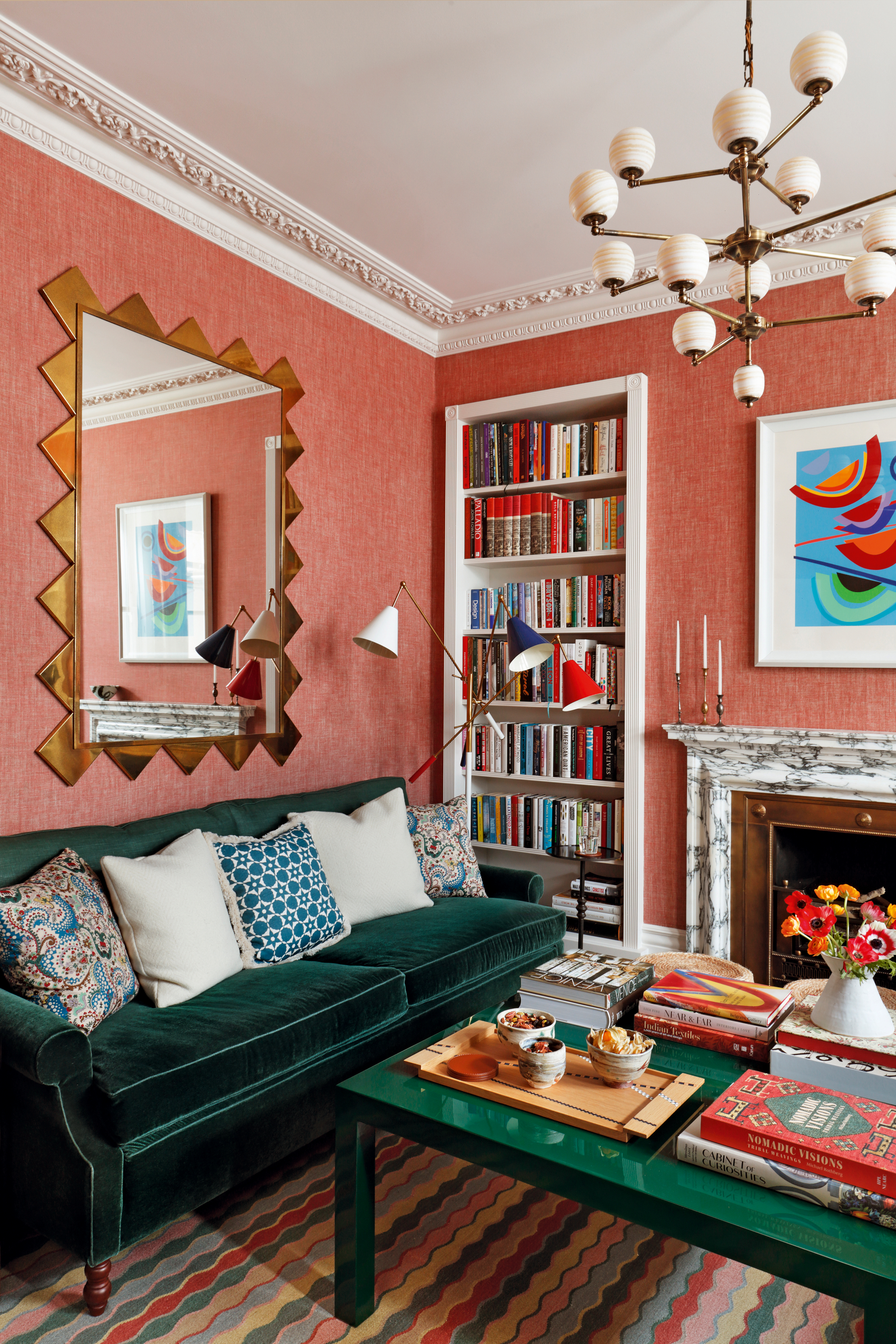 Living room with coral walls, deep green velvet sofa, dark green glossy coffee table and white ceiling and woodwork