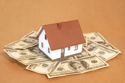 model house with a brown roof on one hundred dollar bills