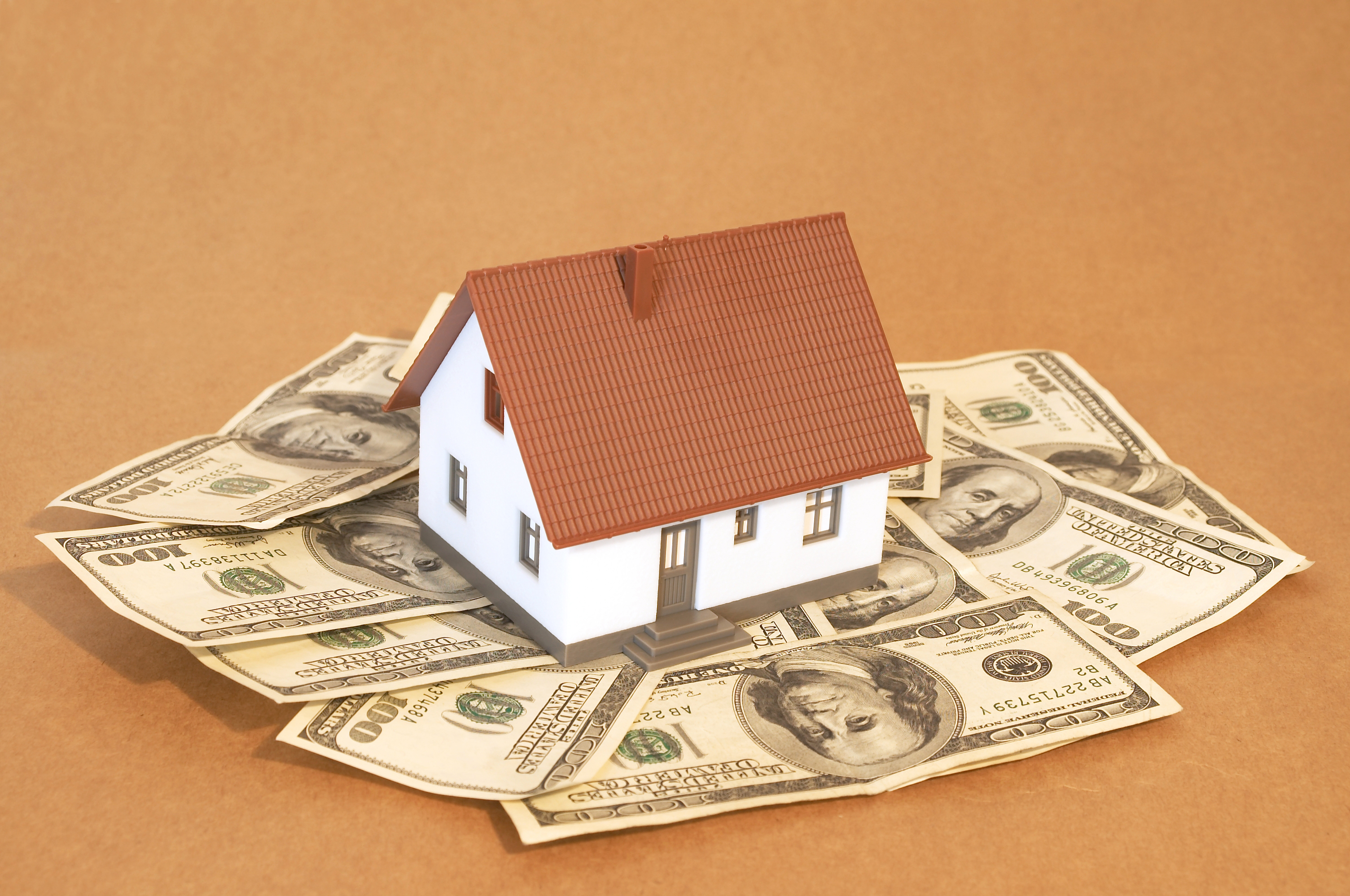 model house with a brown roof on one hundred dollar bills