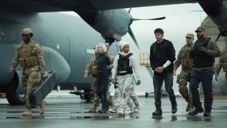 Owen, Dawn, Nichka, and Lester walk through an air base in The Recruit season 2