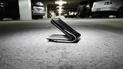 Wallet on concrete in parking garage (focus on wallet) 