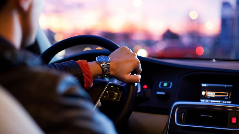 A man driving a car in the evening.