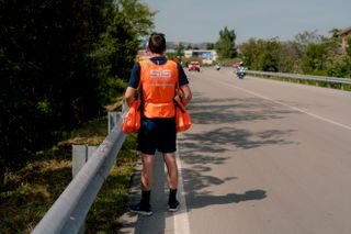 A soigneur waits for the peloton to approach the feed zone at the Giro d'Italia