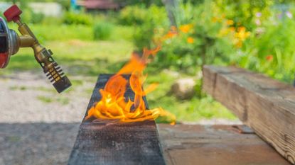 Burning raised bed lumber with a blowtorch