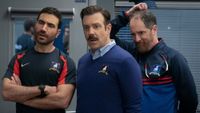 From left to right: Brett Goldstein folding his arms, Jason Sudeikis standing and Brendan Hunt scratching his head. They all look confused.