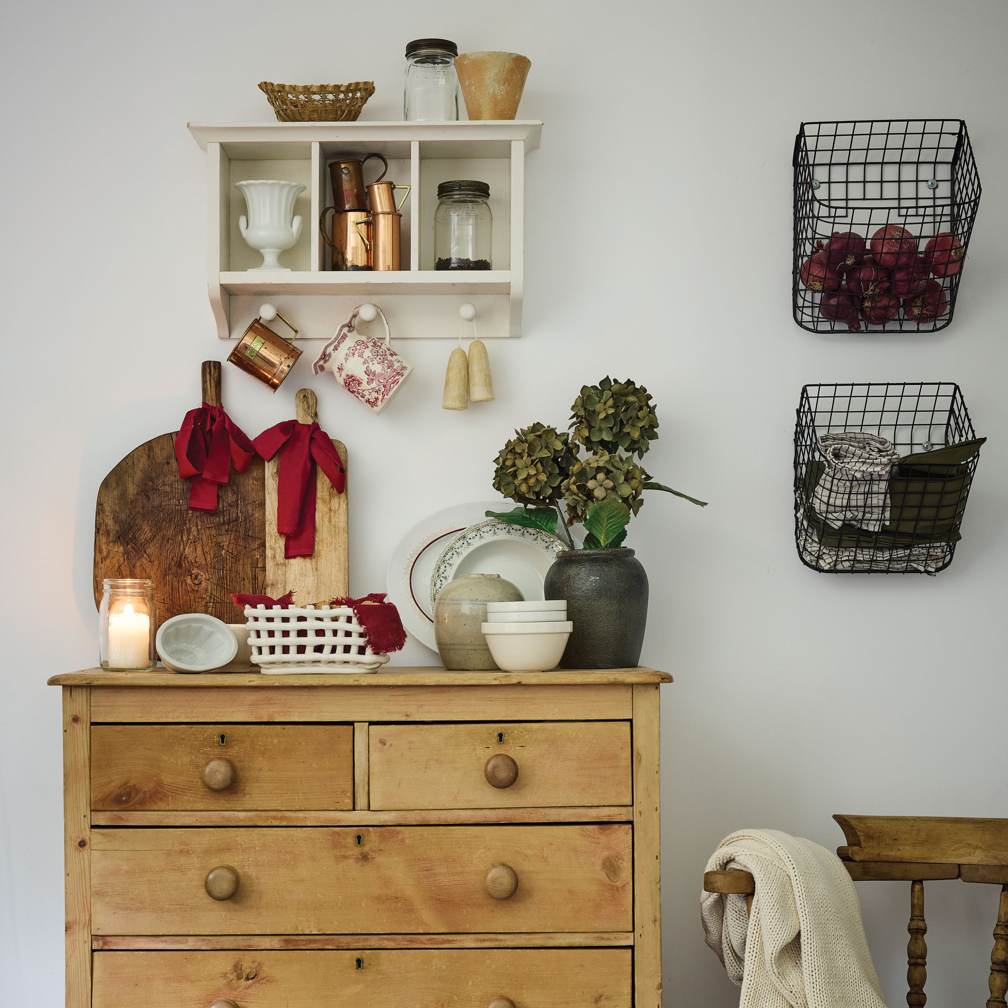 White bedroom with wooden dresser and wire baskets